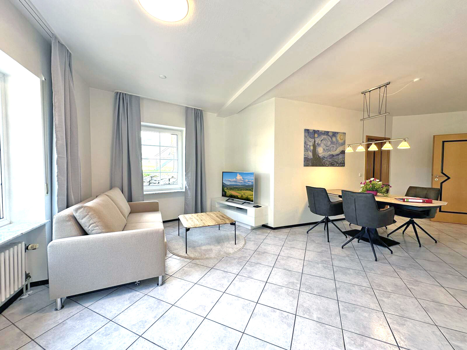 Heller Wohnbereich mit Sofa, Esstisch und Küche im Hofgut Rombach